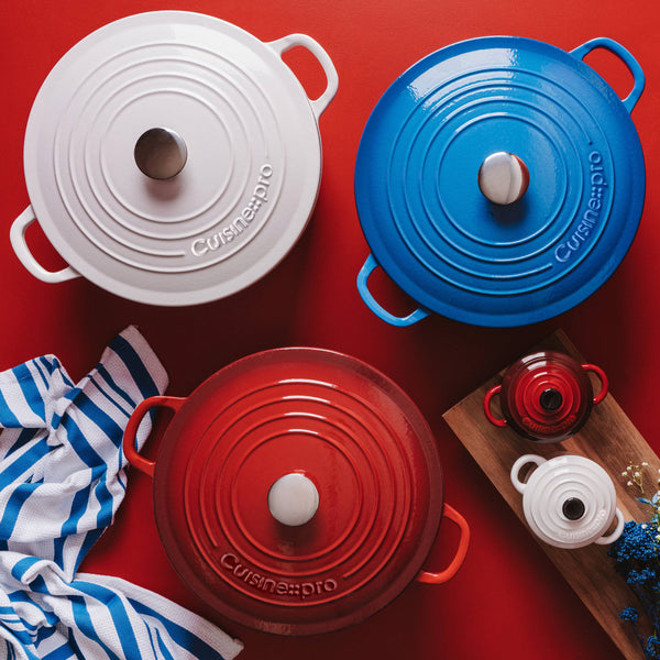 Cuisine::pro® LE CONNOISSEUR™ 6.6 Qt. Round French Oven collection in red, white, and blue on a vibrant background.