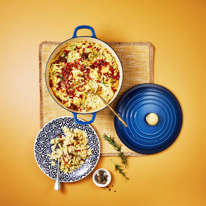 Cuisine::pro® LE CONNOISSEUR™ 6.6 Qt. Round French Oven with rice dish on a blue plate.